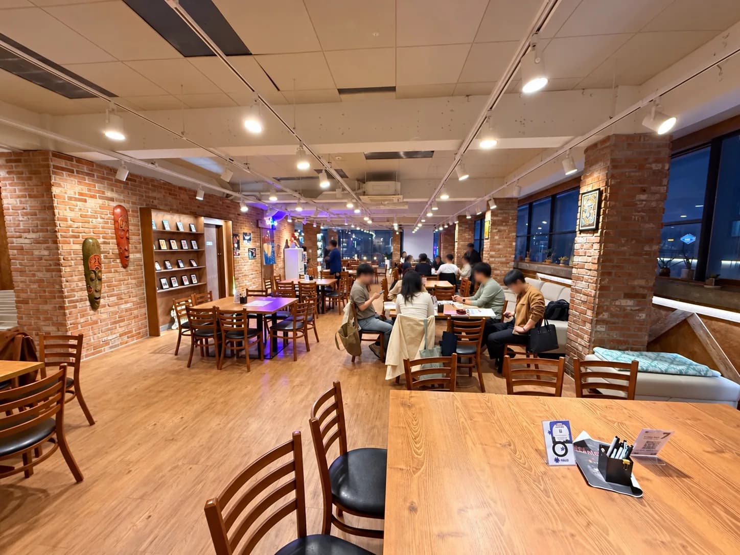 팔로 영등포점의 벽돌 벽과 목재 테이블, 창가 쪽에 모여 앉은 스터디 참가자들
